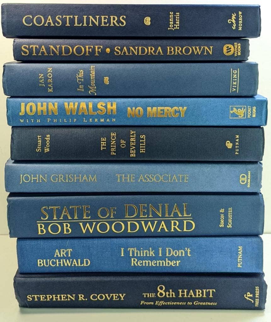Blue books with gold  titles by the foot for decor